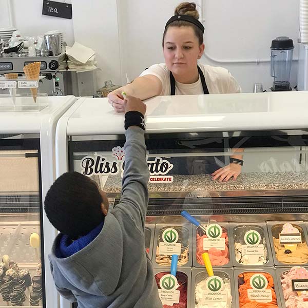 A Young Employee Serves a Child a Gelato Free Sample in their Stoney Creek Shop